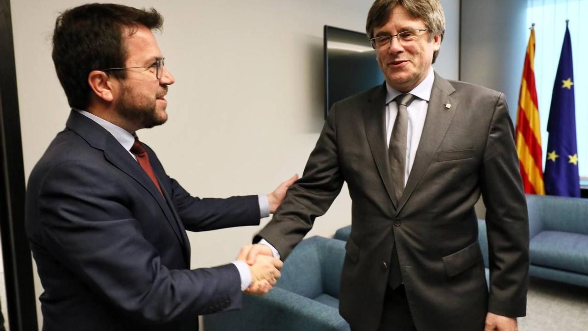 El president de la Generalitat, Pere Aragonès, i el president del Consell per la República i eurodiputat, Carles Puigdemont, estrenyen la mà durant una trobada al Parlament Europeu