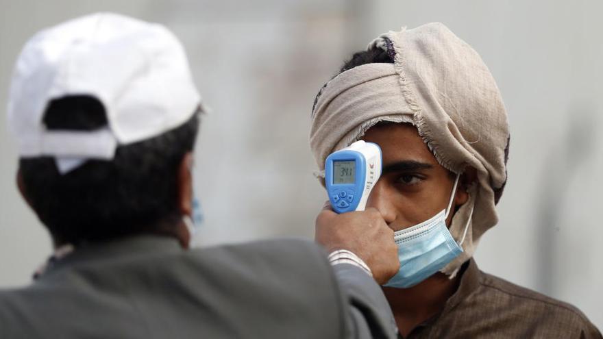 Un sanitario realiza un control de temperatura en Yemen