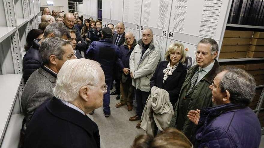 A la derecha, de espaldas, Eduardo Núñez enseña a la familia de Luis Adaro y a una veintena de asistentes el nuevo sótano que alberga la hemeroteca de la ciudad.