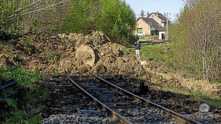 A dalt, la gran esllavissada de terres sobre les vies del Tren Groc. A baix, el fang i l&#039;aigua vessada en uns terrenys adjacents