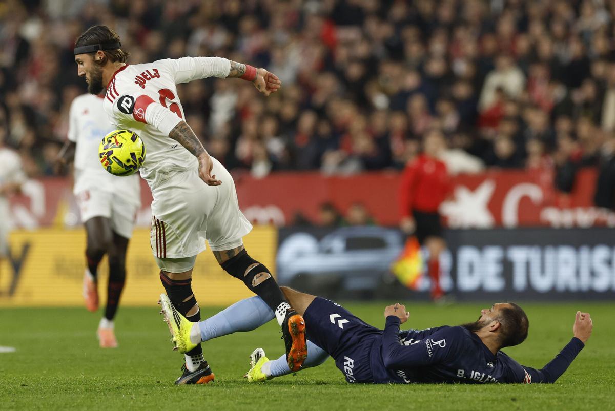 El defensa serbio del Sevilla Nemanja Gudelj (i) intenta escaparse de Borja Iglesias.