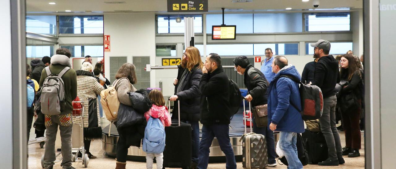Pasajeros recogiendo sus maletas en el aeropuerto de Peinador en una imagen de archivo.