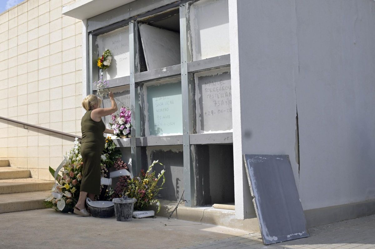 Una mujer arregla un nicho en el Cementerio Nuevo de Elche