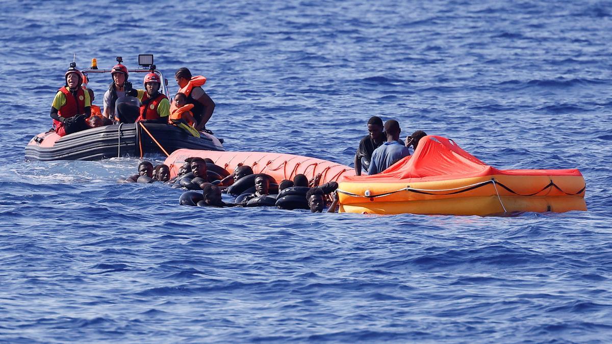 Migrantes, en un bote de hierro y en el agua, son asistidos por miembros del barco de rescate &quot;Astral&quot; de la ONG Open Arms en aguas internacionales al sur de Lampedusa, en el Mar Mediterráneo central