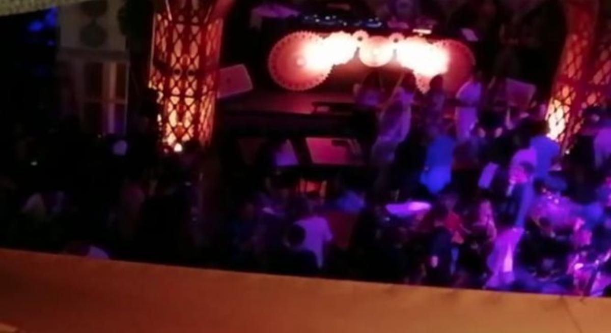 Imagen del interior del restaurante denunciado en el que se ve a varios clientes de pie bailando.