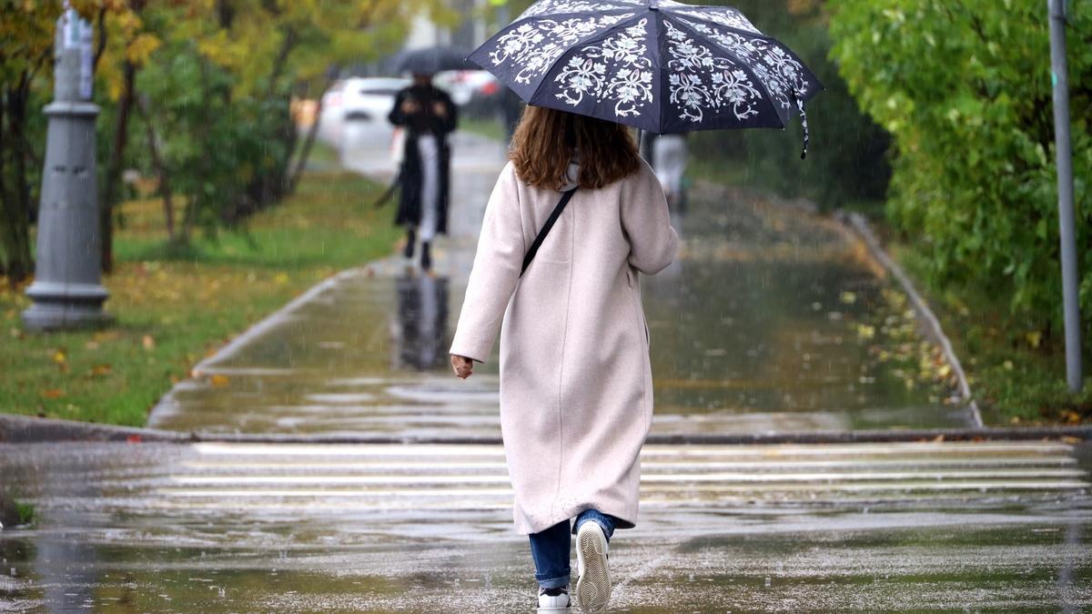 Una persona paseando bajo la lluvia.