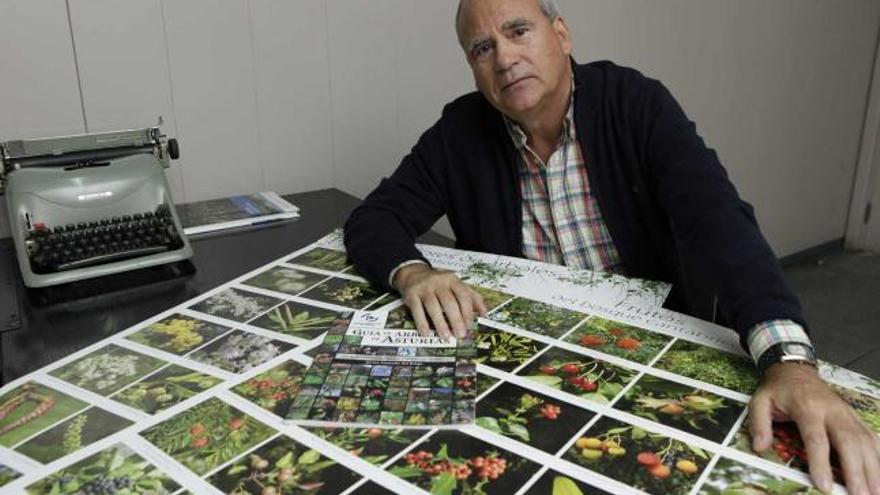 Javier Castaño, con su guía de árboles y varios carteles con fotos de especies autóctonas.