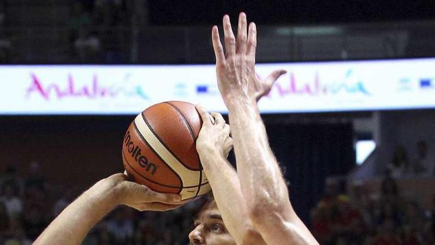 Calderón lanzando a canasta ante un jugador lituano.