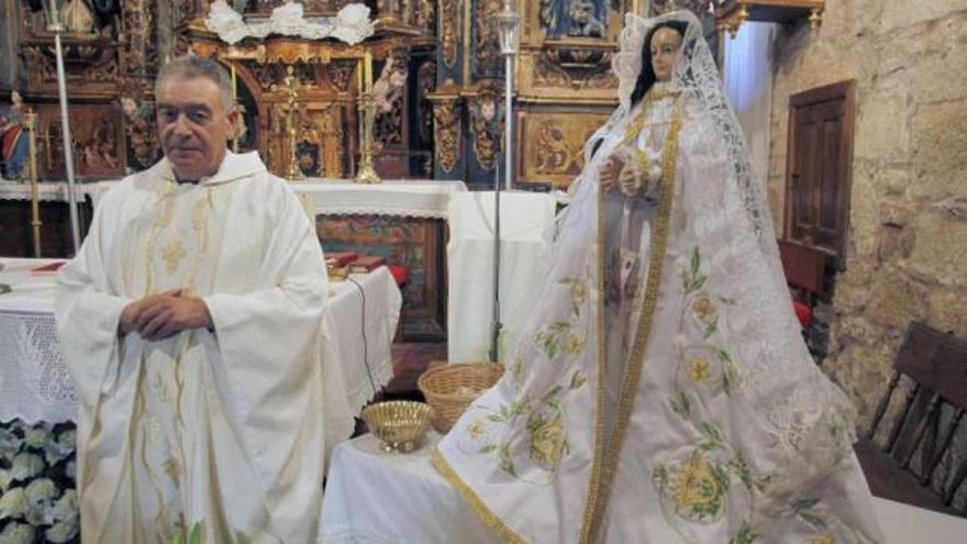 Manuel Civeira, párroco de Dozón, en la iglesia de Santa María, con la talla de la Virgen.  // Bernabé/Gutier