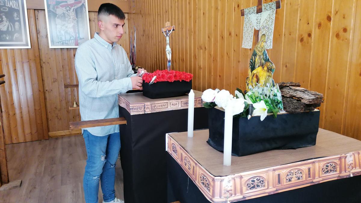 El joven toresano coloca unas flores en uno de los pasos de la colección