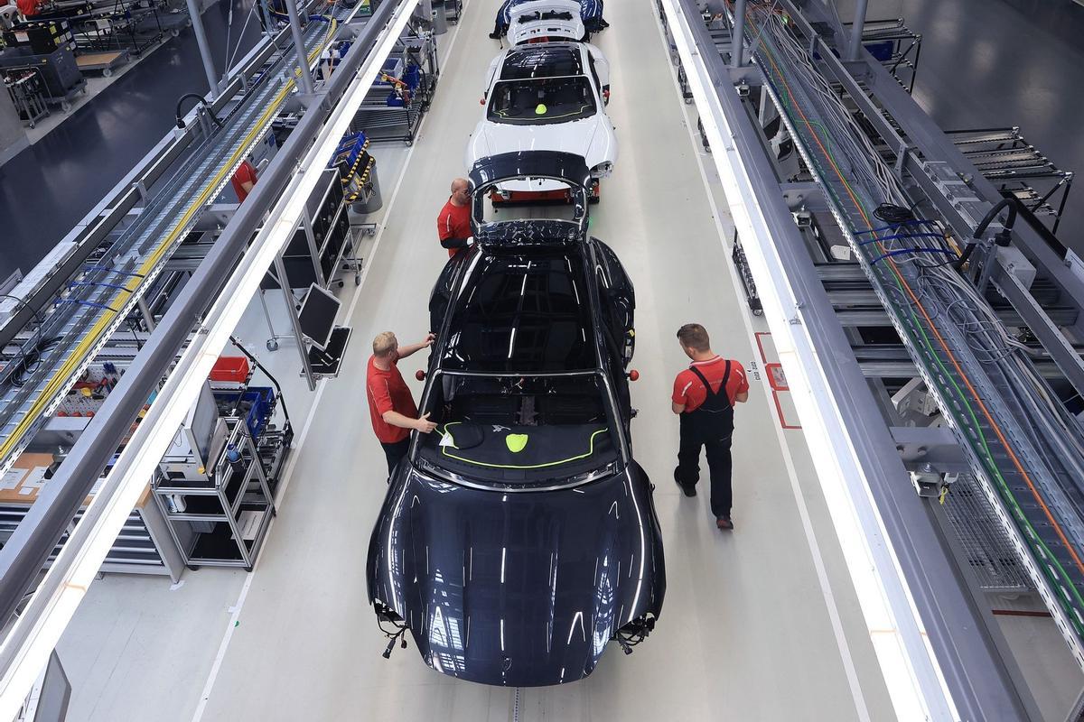 Los empleados trabajan en las carrocerías de los automóviles de lujo Porsche Taycan totalmente eléctricos en la línea de producción de la fábrica de Porsche AG en Stuttgart, Alemania.