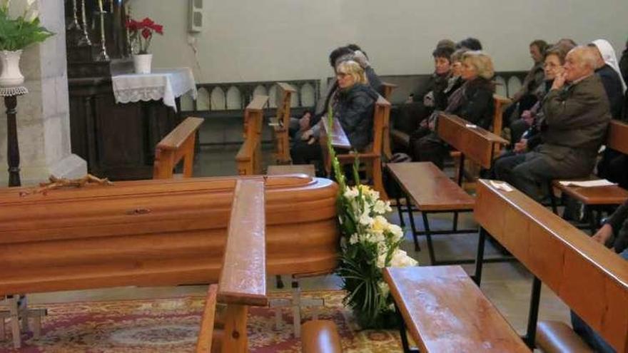 Asistentes al funeral, con el féretro en primer término.