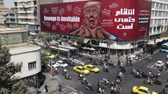 Trànsit a la capital iraniana Teheran davant d’una tanca publicitària contra Trump, dimecres passat. | ABEDIN TAHERKENAREH / EFE