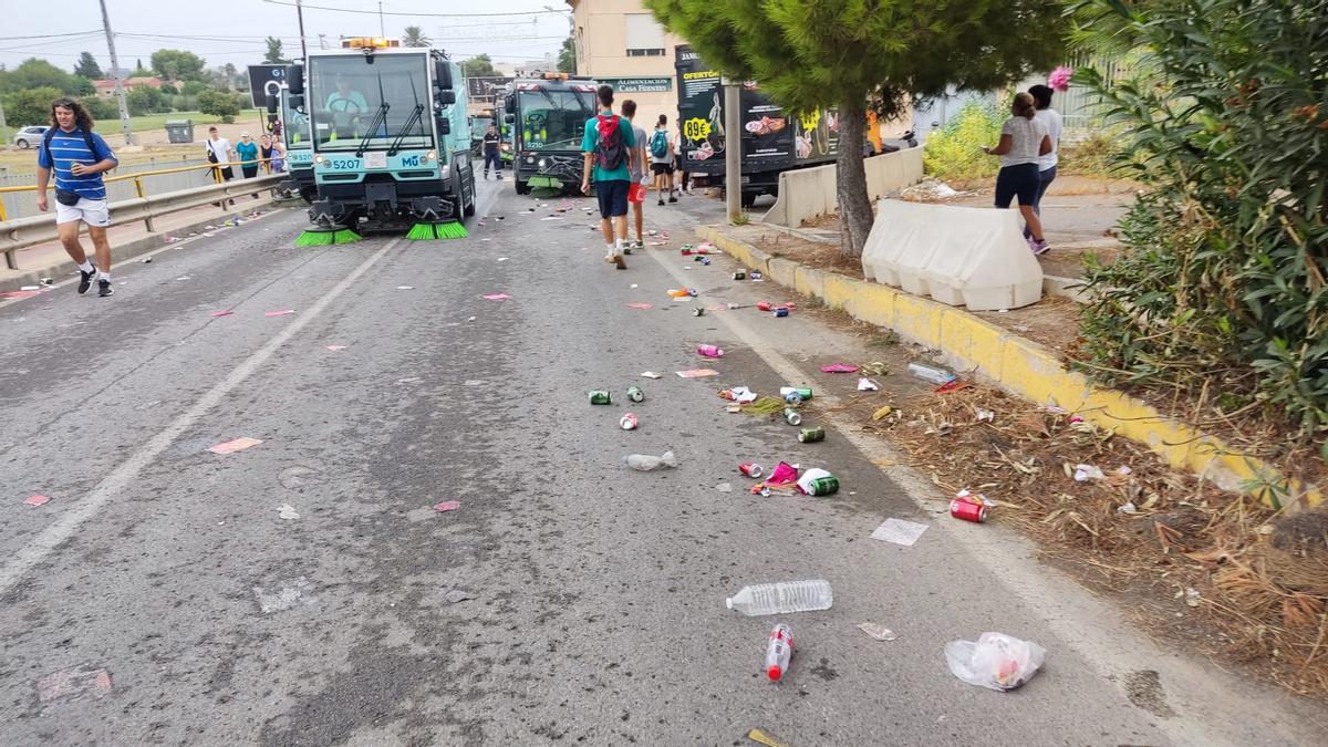 Operarios de limpieza siguen la marcha de los fieles.