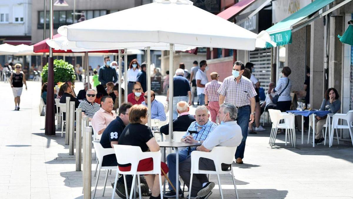 Clientes con y sin mascarilla en la terraza de un bar en Marín.