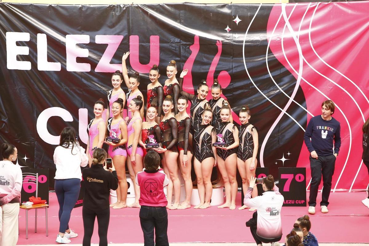 El equipo juvenil recogiendo el primer premio en el podio, junto a sus competidores.