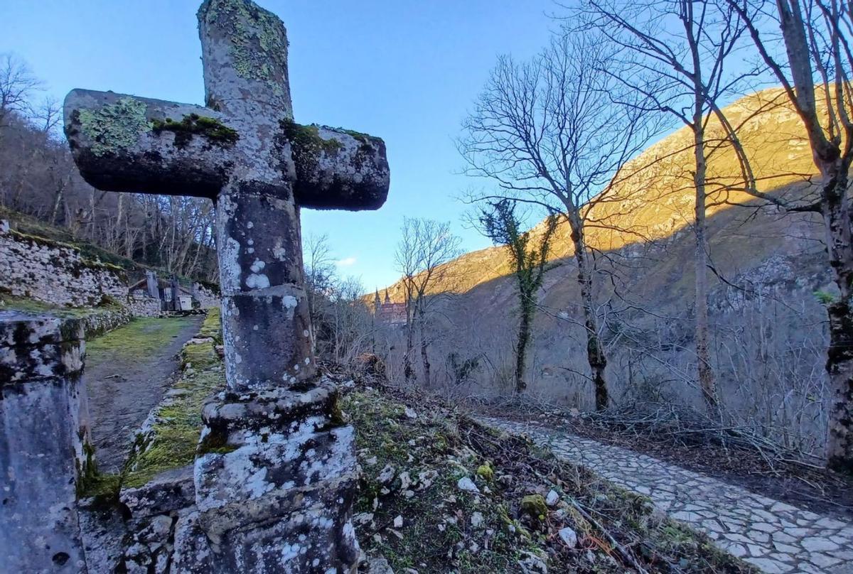 A la izquierda, la gran cruz que preside la entrada al cementerio de Covadonga. Arriba, a la derecha, la «fuente canapé». Debajo, dos moteros, con la basílica al fondo. | P. T. |  P. T.