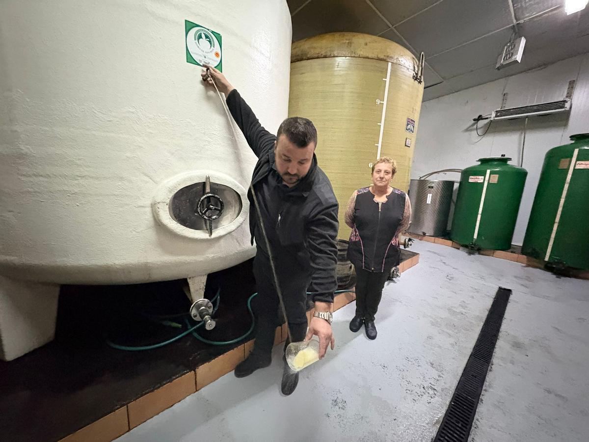 Javier Díaz escancia un culete en la bodega del Llagar Alonso en presencia de su madre, Mari Camblor