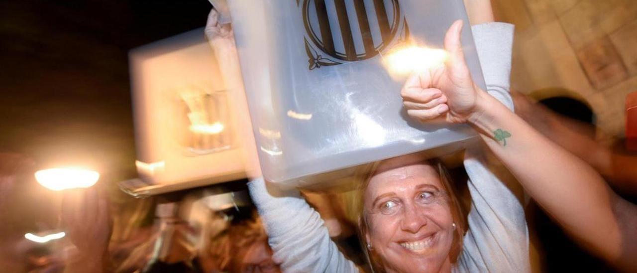 Una mujer sostiene una urna en el consulta en Cataluña en 2017.