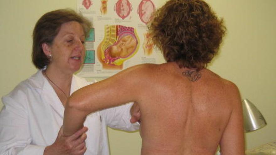 Una doctora realiza una mamografía a una paciente.
