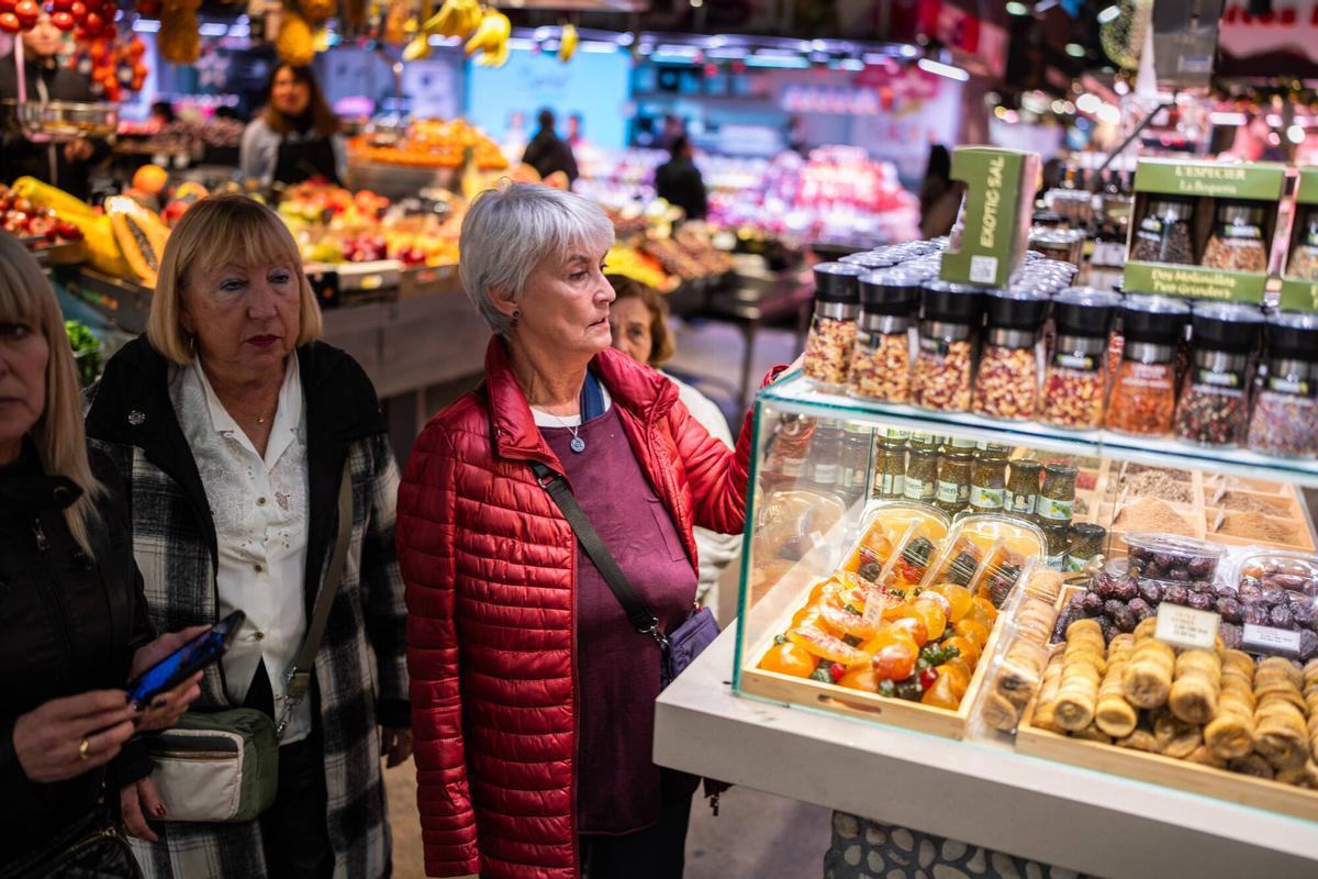 La clientela local compra en sus paradas preferidas del Mercat de la Boqueria