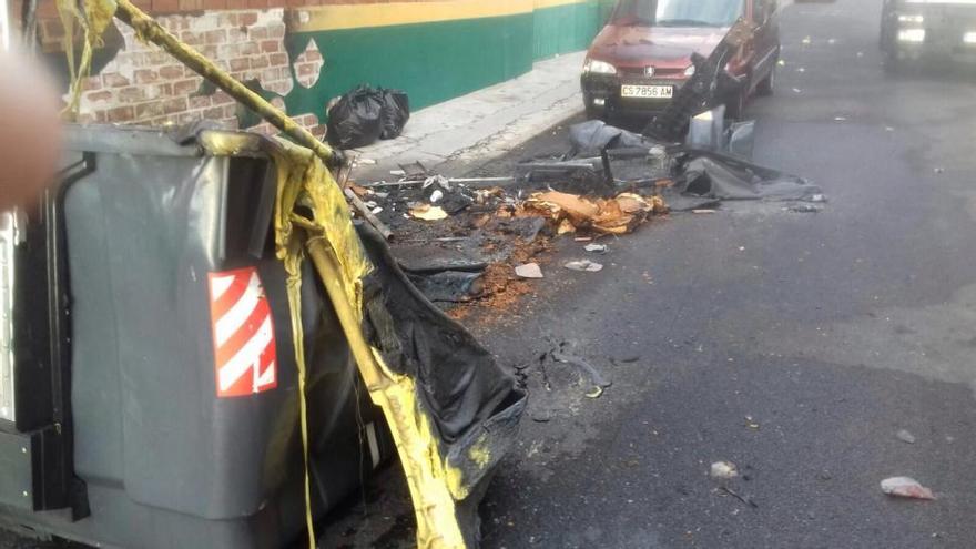 Arden dos contenedores, una papelera y un árbol en la Vilavella durante la celebración de las fiestas