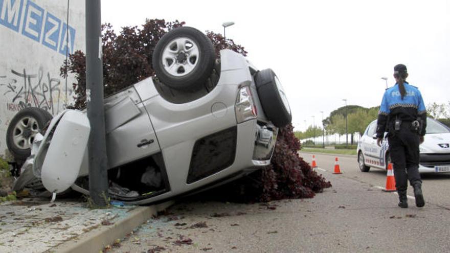 Un coche se estrella contra un árbol y una farola en la carretera de La Aldehuela