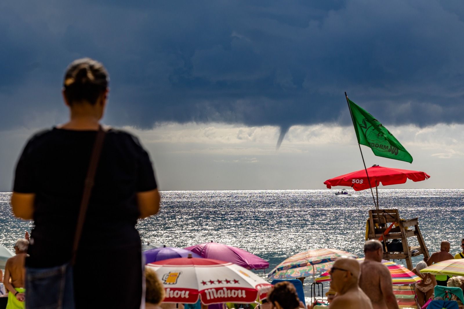 Los bañistas permanecen en las playas de Benidorm pese a la amenaza de lluvias