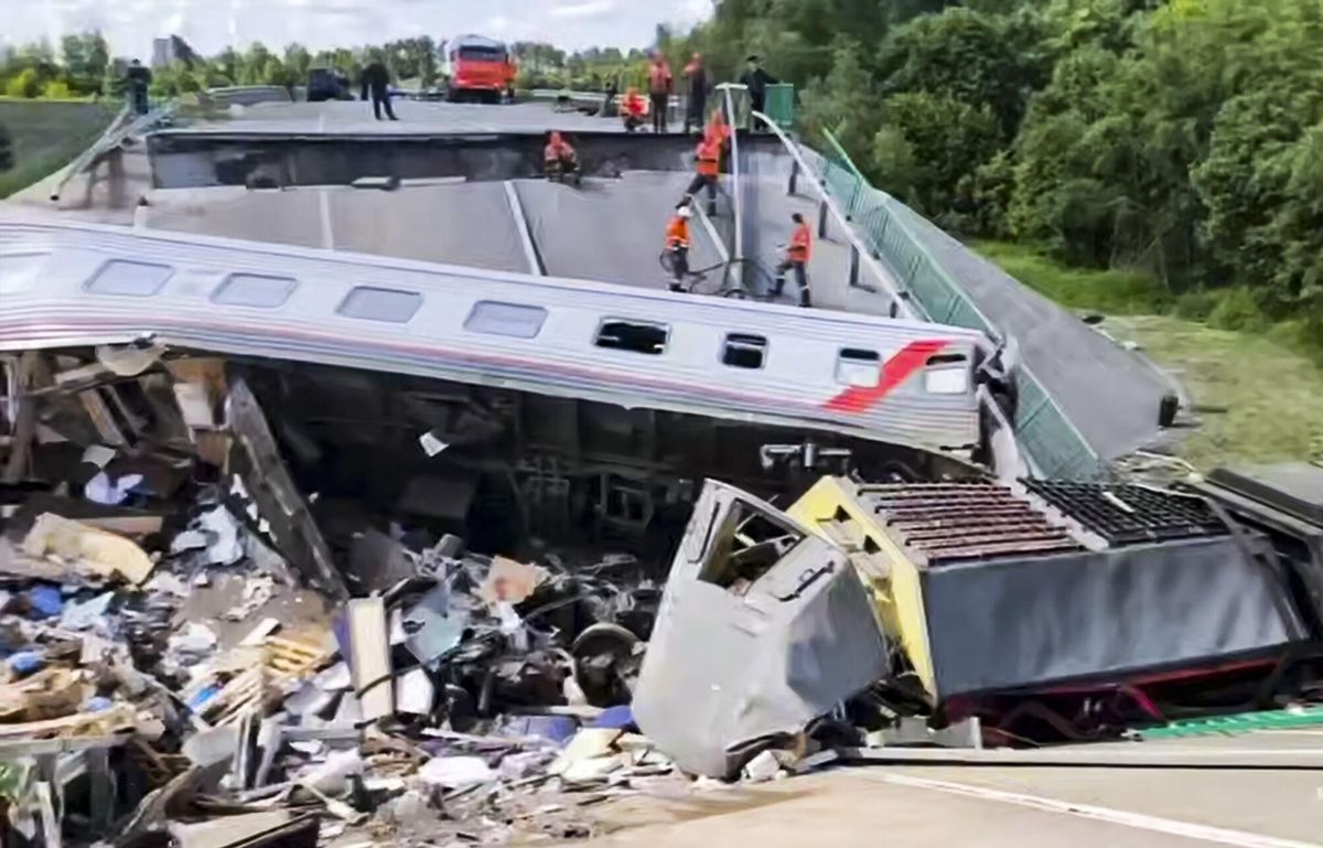 Rescatistas rusos trabajan en el lugar donde se derrumbó un puente sobre un tren de pasajeros en la región de Briansk.