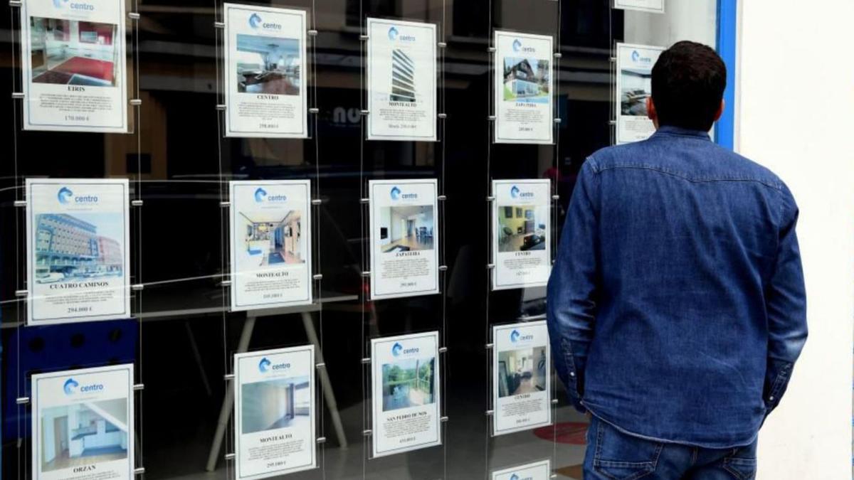 Un hombre mira el escaparate de una inmobiliaria coruñesa. |   // VÍCTOR ECHAVE
