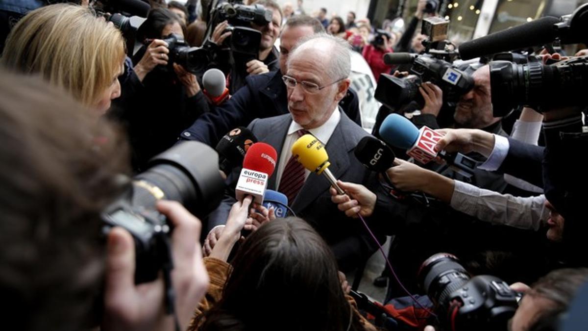 Rodrigo Rato, rodeado de medios, llega a su despacho en Madrid.