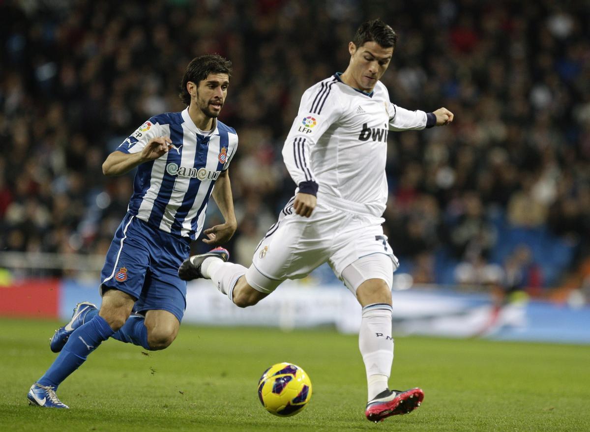 GRA170. MADRID, 16/12/2012.- El delantero portugués del Real Madrid Cristiano Ronaldo (d) intenta un disparo a portería ante el defensa argentino del RCD Espanyol Diego Colotto, durante el encuentro correspondiente a la decimosexta jornada de liga en Primera División, esta noche en el estadio Santiago Bernabéu. EFE/Víctor Lerena. Cristiano Ronaldo, Diego Colotto / Fútbol, futbolistas, partidos, equipos Real Madrid, Espanyol, temporadas 12-13