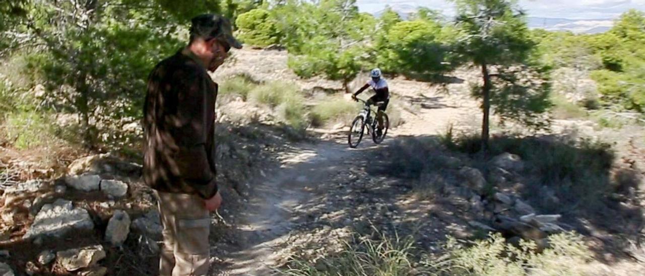 Un cazador en uno de los senderos de Monte Orgegia, con un ciclista al fondo. | JOSE NAVARRO