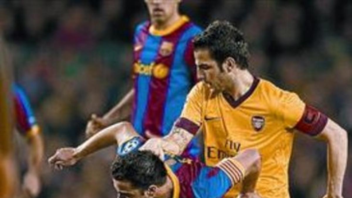 Cesc intenta arrebatar un balón a Xavi, anoche en el Camp Nou.