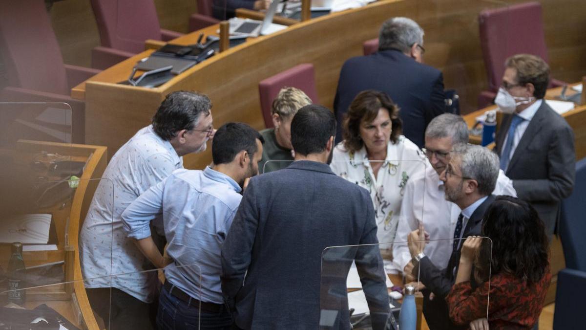 Diputados del PSPV y Compromís conversan durante el debate de política general.