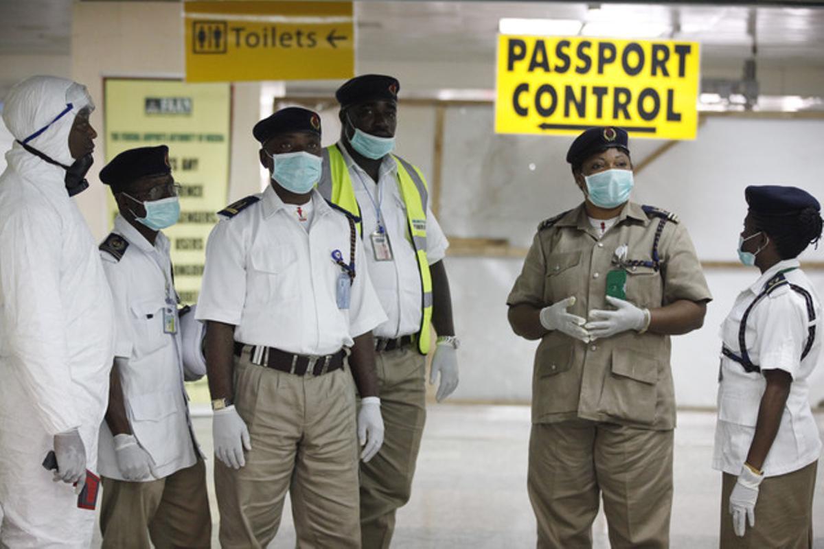 Membres del servei de salut nigerians esperen a l’aeroport internacional de Lagos, aquest dilluns.
