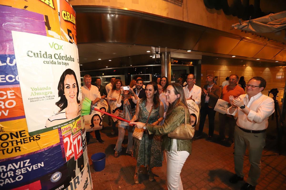 Yolanda Almagro y Paula Badanelli pegan un cartel electoral.