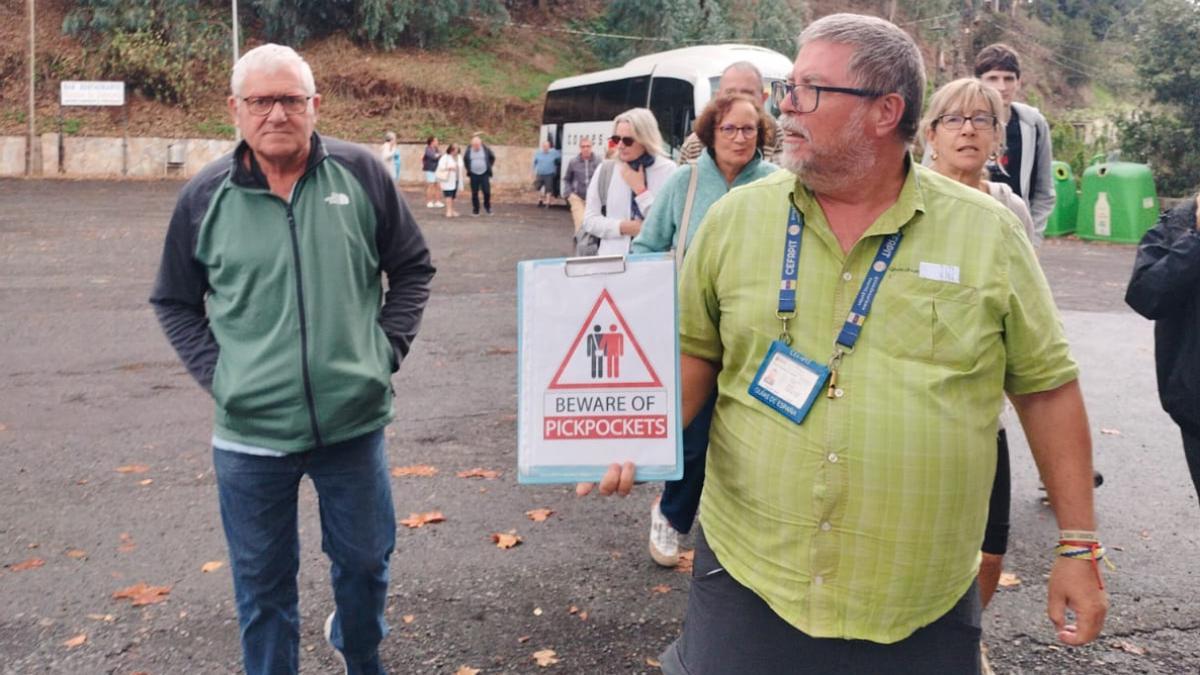 Un guía turístico porta un cartel que avisa de la presencia de carteristas.
