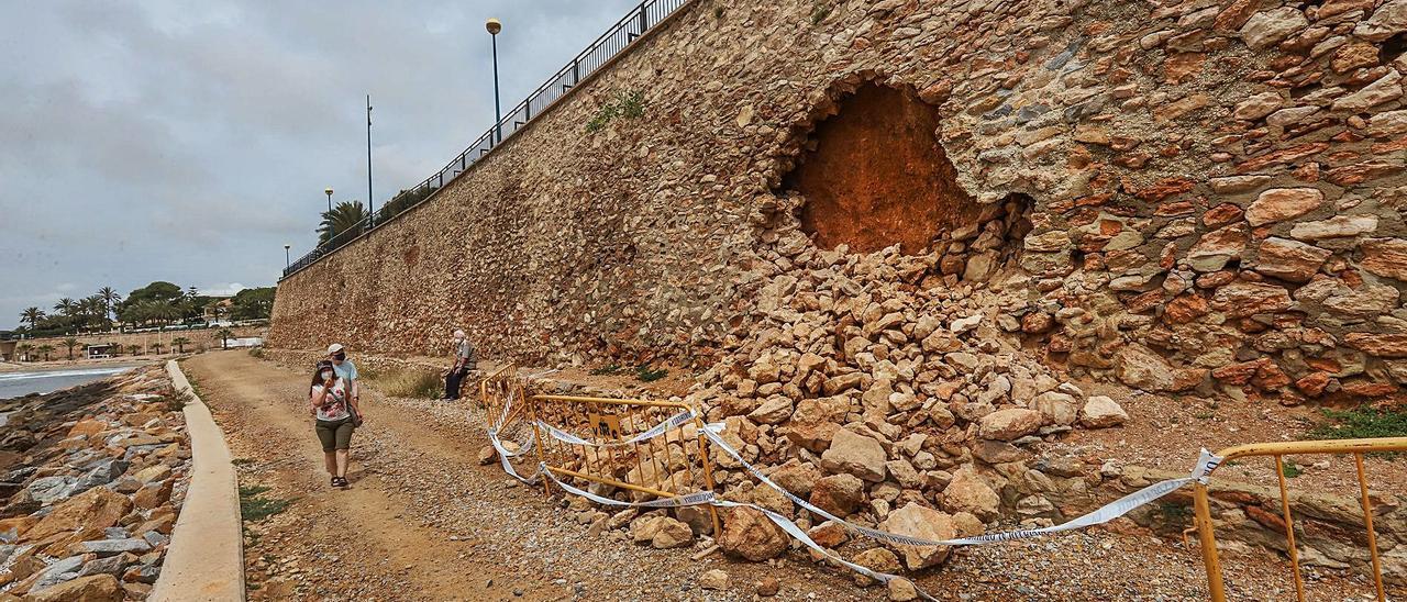 El desprendimiento de las rocas del muro del paseo de Punta Prima ha dejado un gran boquete y ha obligado a vallar la zona. |