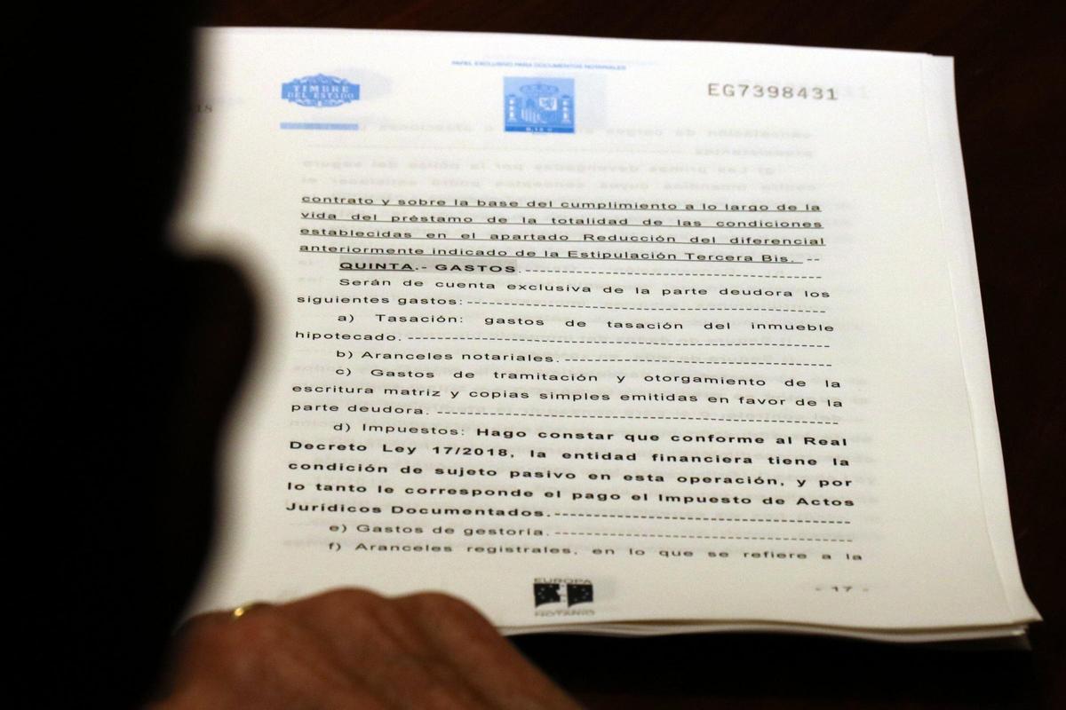 Un notari amb l'escriptura on es detalla que el banc ha d'assumir l'impost sobre hipoteques, el 12 de novembre del 2018