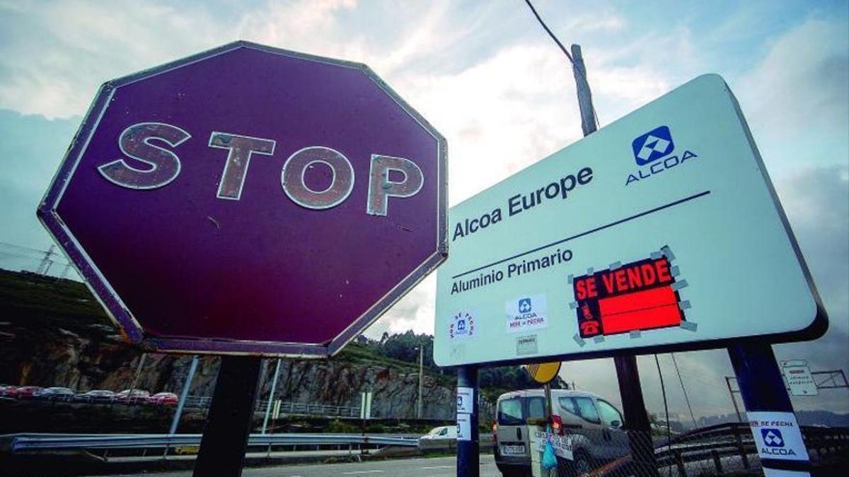 Una señal de stop y un panel informativo, a la entrada de Alu Ibérica en A Grela.