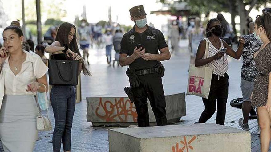 Un Policía, ayer, avisa del uso obligatorio de la mascarilla.