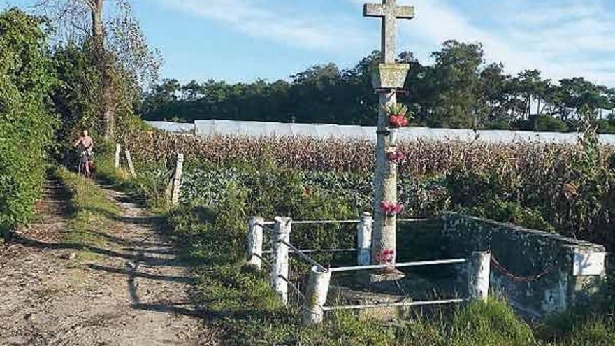 El camino pasa cerca de campos y cruces de piedra.