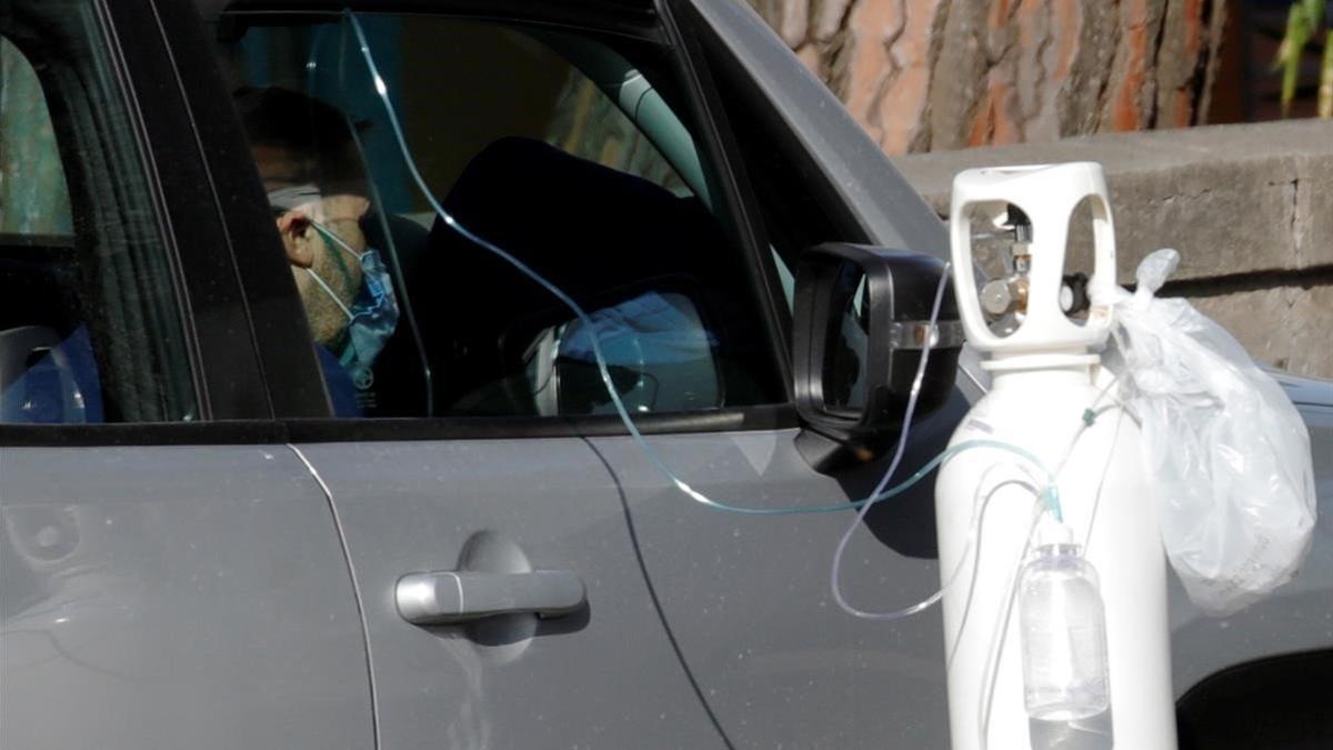 Un paciente recibe oxígeno en su coche mientras espera a ser atendido en Nápoles.