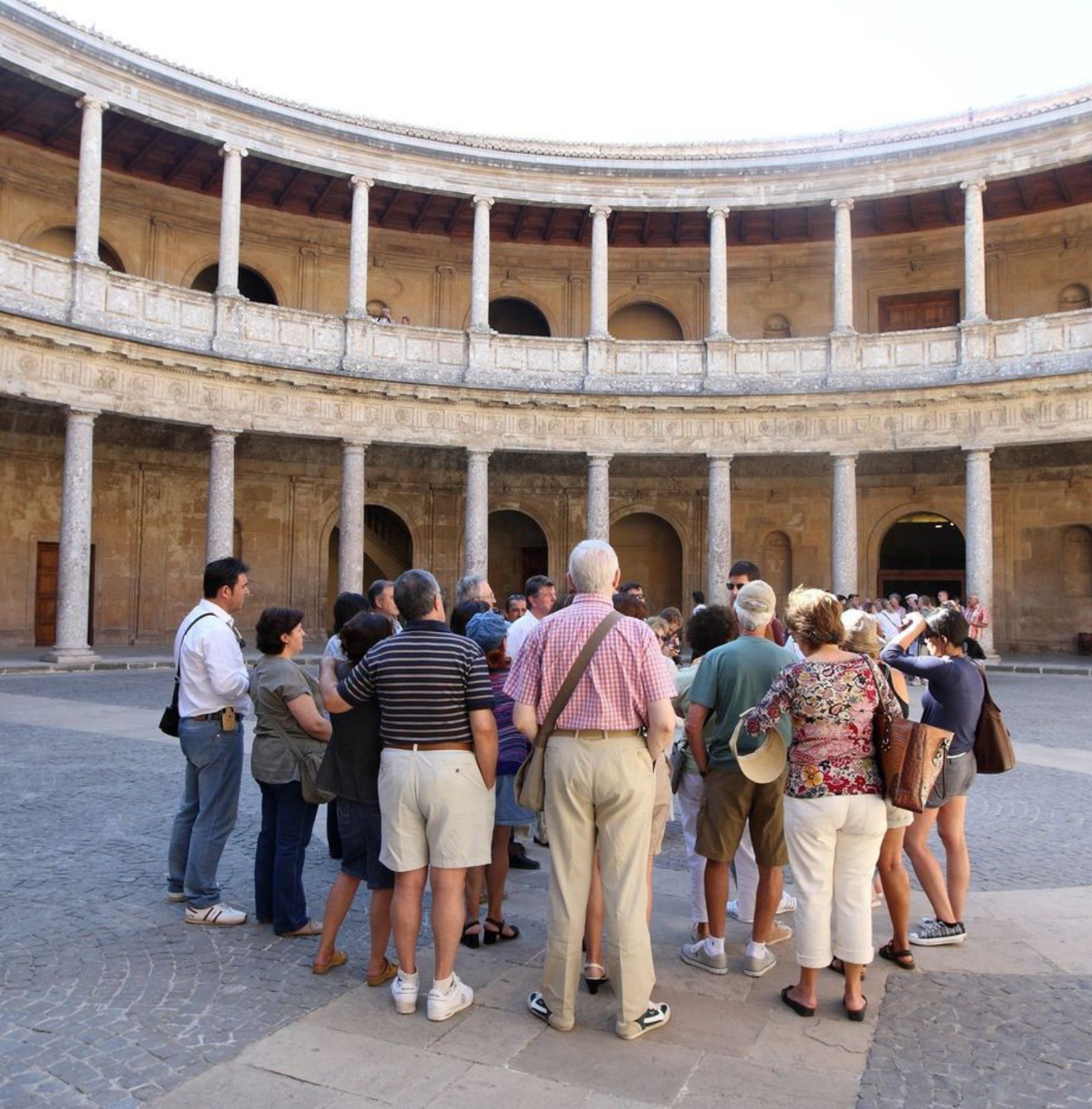 Turismo en Granada: Un grupo de turistas atiende a un guía.