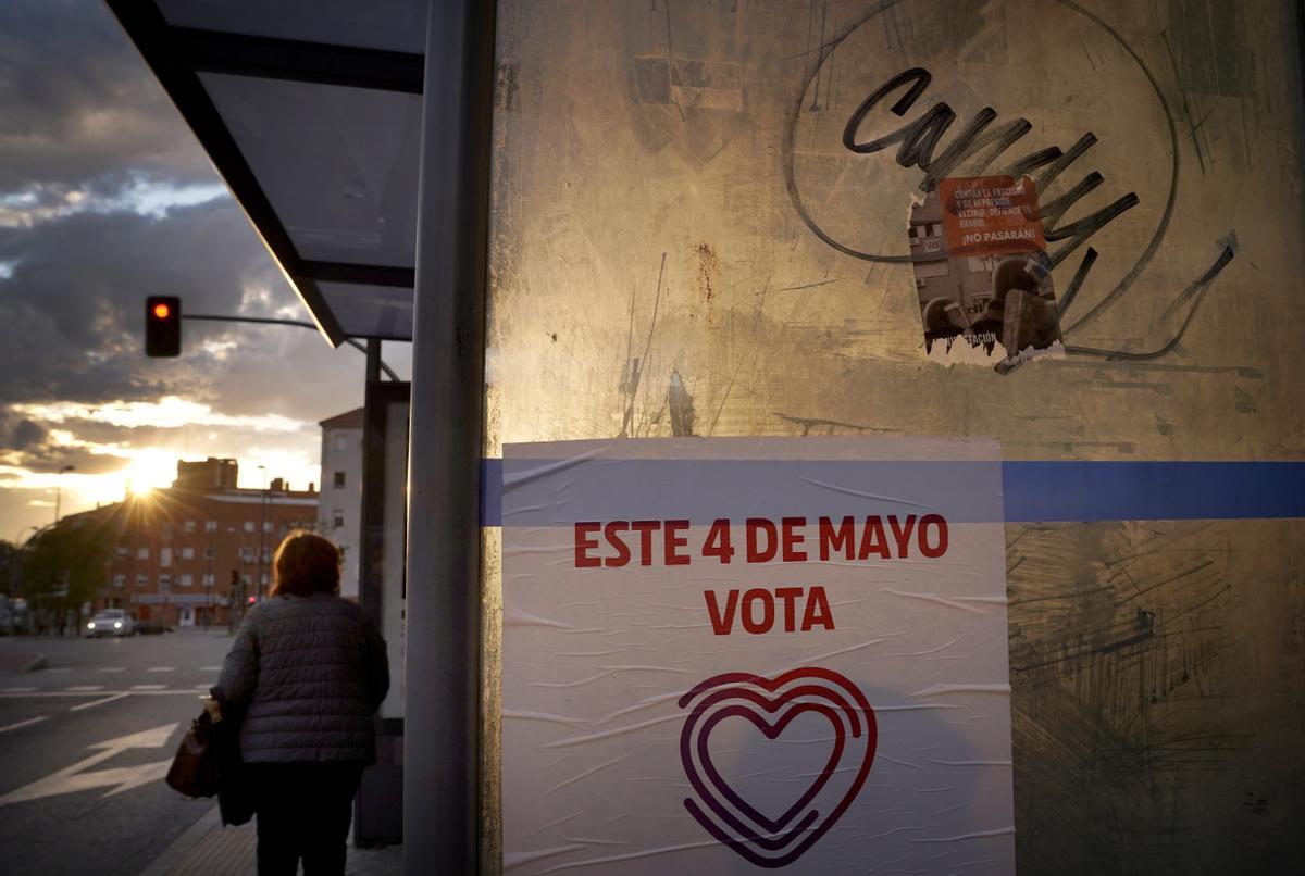 Una parada de  autobús con un cartel electoral en el barrio de Vallecas.