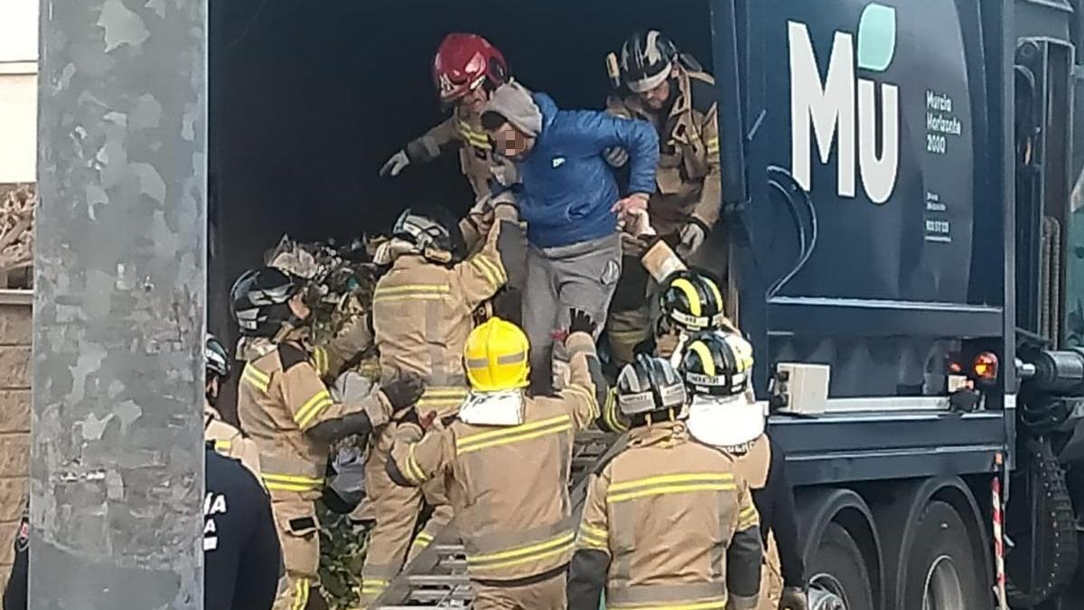 Los bomberos de Murcia ayudan al joven a salir del camión de la basura, en Casillas.