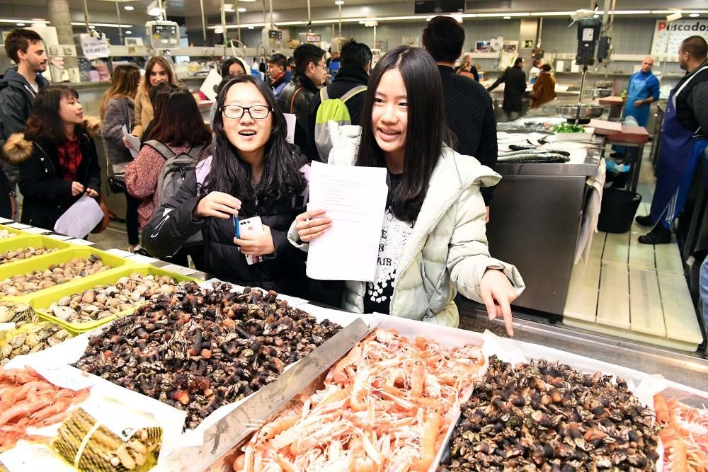 Una treintena de alumnos del Centro de Linguas de la Universidad coruñesa procedentes de China y Vietnam visitan el mercado de la plaza de Lugo para aprender argot gastrónomico gallego.