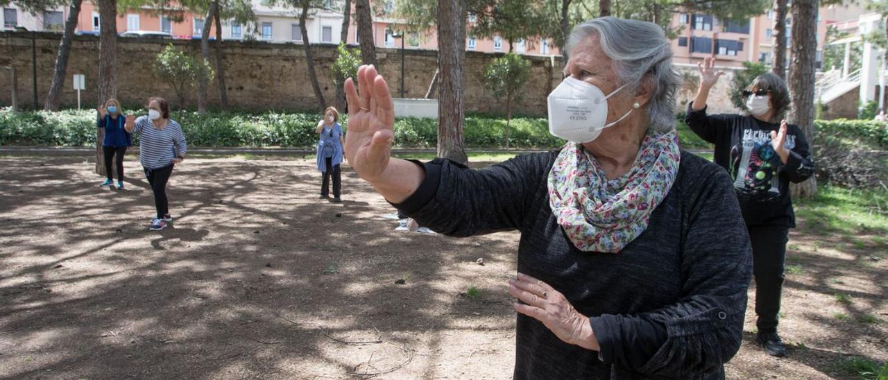 Un grupo de jubilados realiza ejercicio al aire libre en València. | FERNANDO BUSTAMANTE