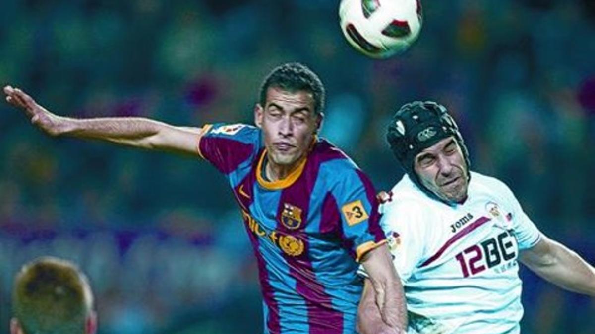 Busquets disputa un balón con Negredo, que jugó con casco por un corte en la cabeza.